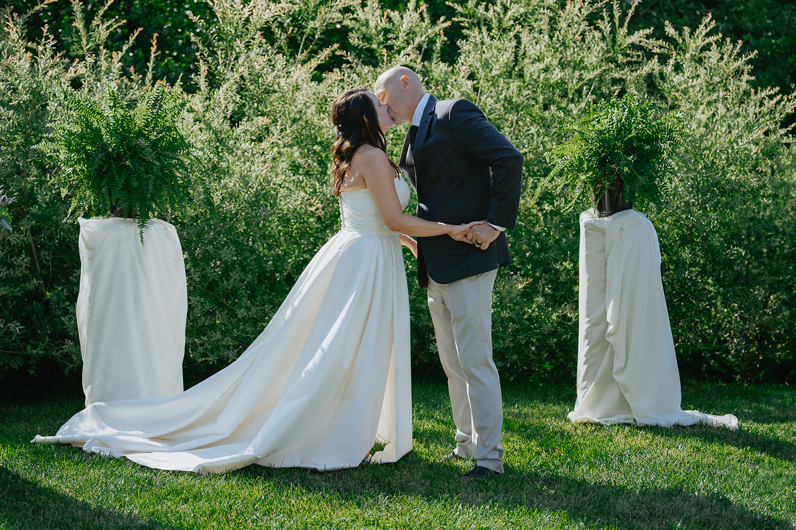 Lawrence KS Wedding a bride and groom share their first kiss outdoors