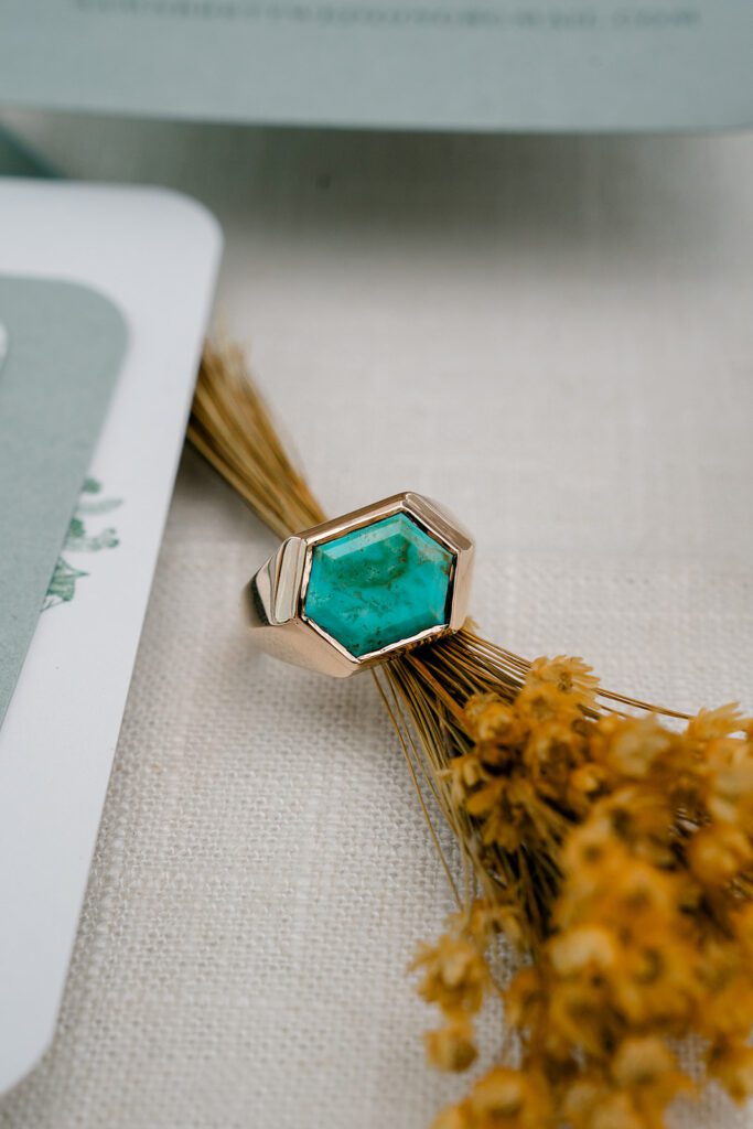 A mens wedding band featuring a large turquoise stone. 