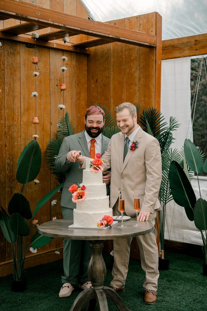 Two grooms cut into their wedding cake at their lawrence wedding venue