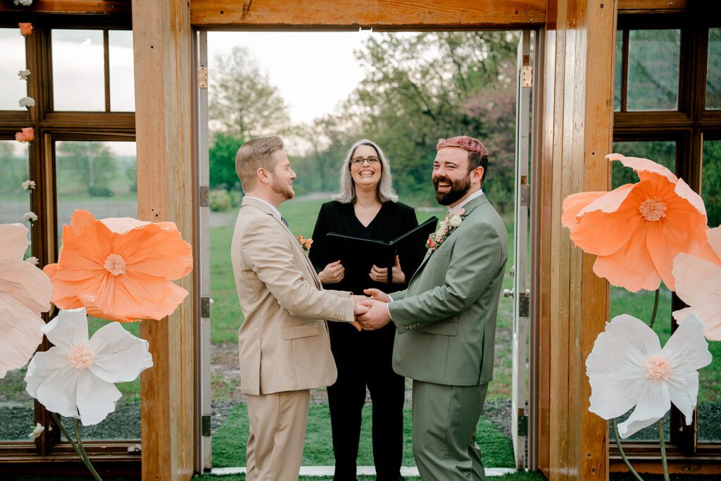 Two grooms exchange vows during their wedding ceremony at Deer Ridge Estates