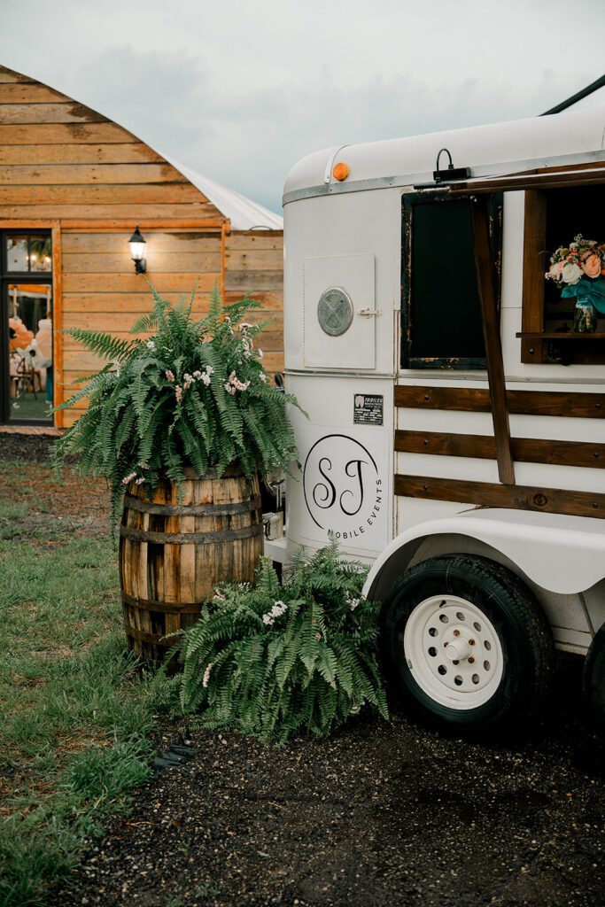A bar trailer sits outside of a greenhouse at Deer Ridge Estates, a wedding venue in lawrence kansas. 