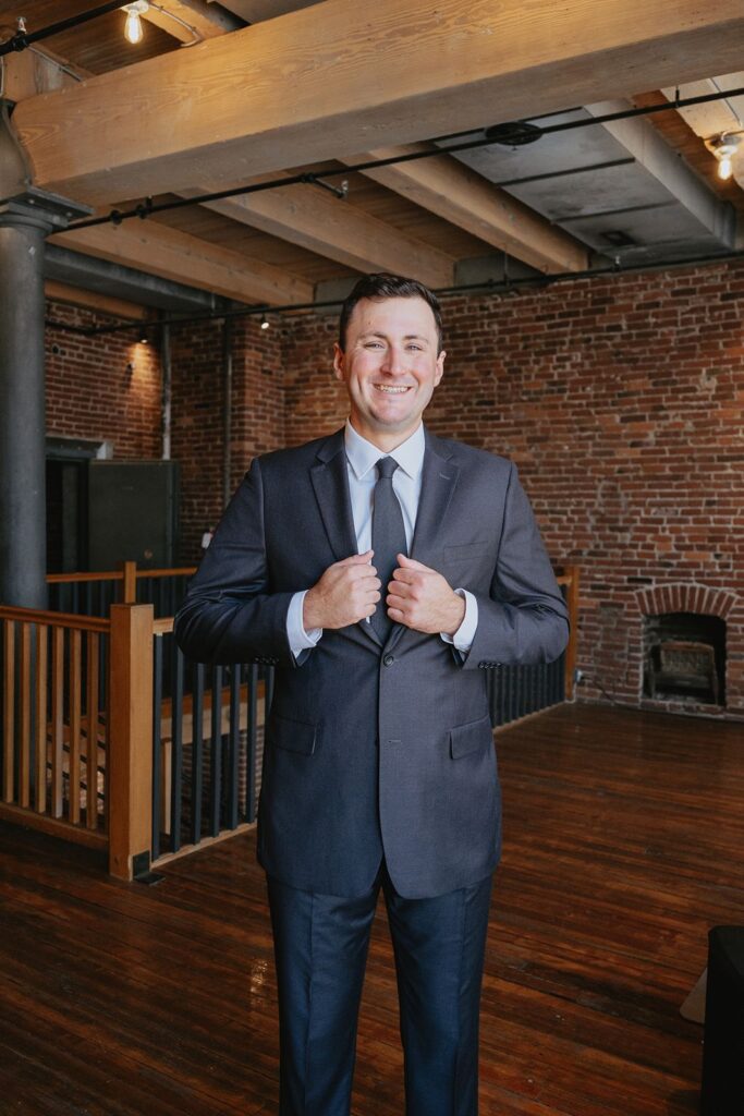A groom smiles at the camera before his wedding ceremony in Kansas City