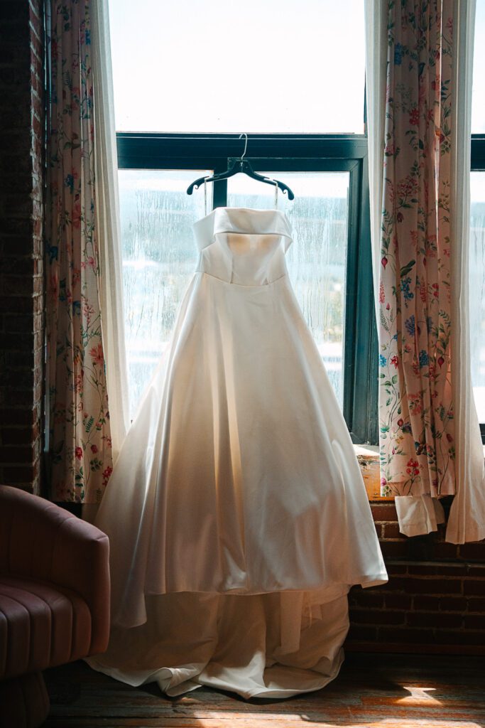 a wedding dress hangs in the window of a KC wedding venue.