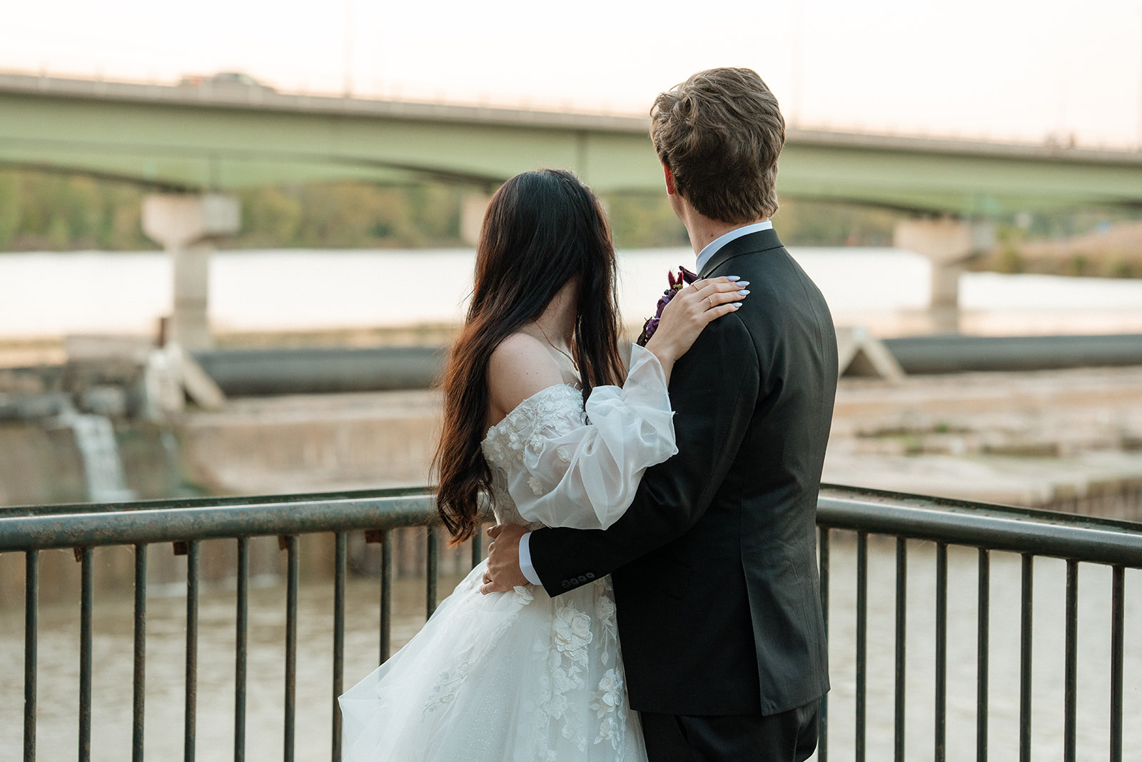 A bride and groom look over the river outside of Lawrence Wedding Venue, Abe and Jakes Landing