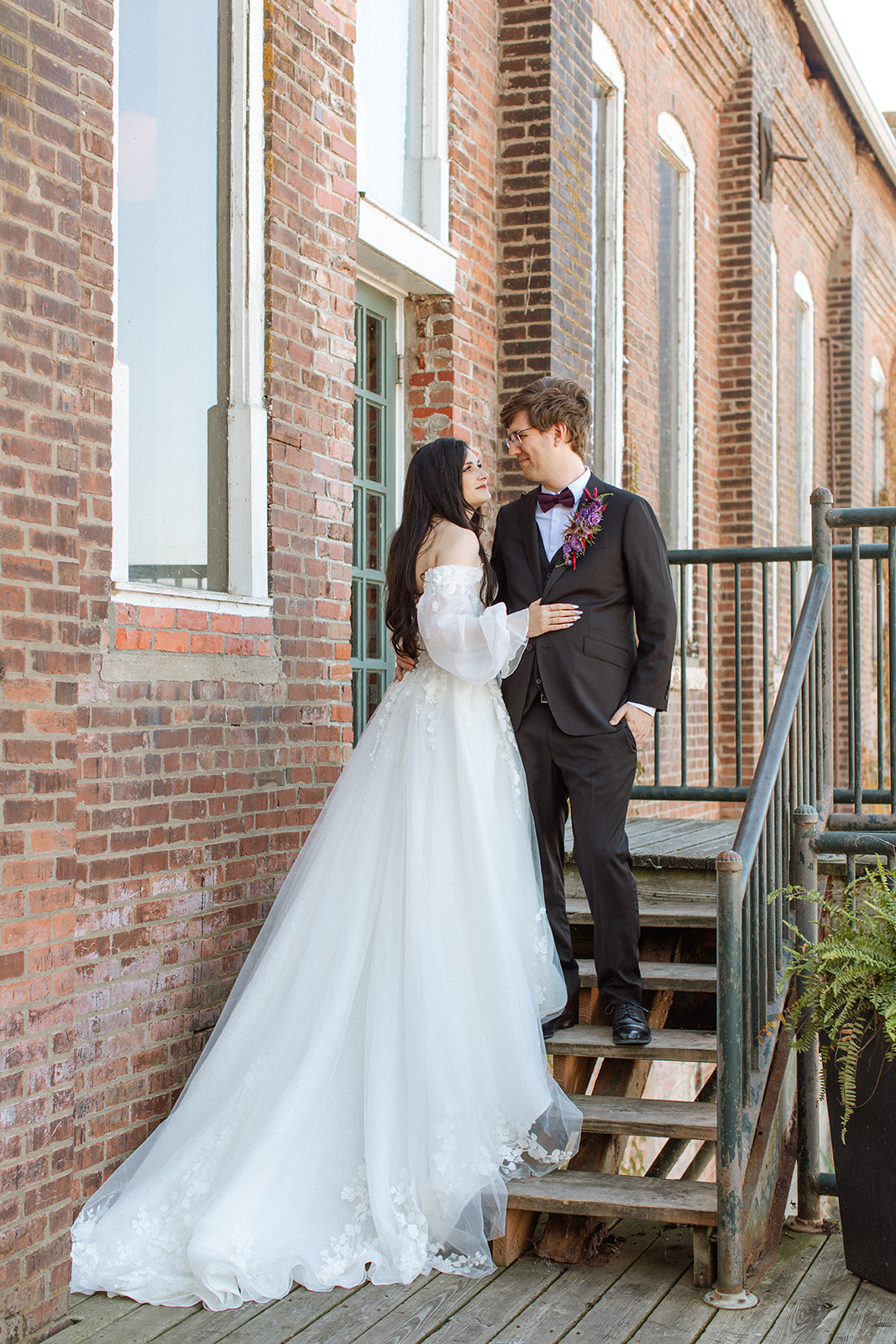 A bride and groom pose together outside of Abe and Jakes Landing in Lawrence KS