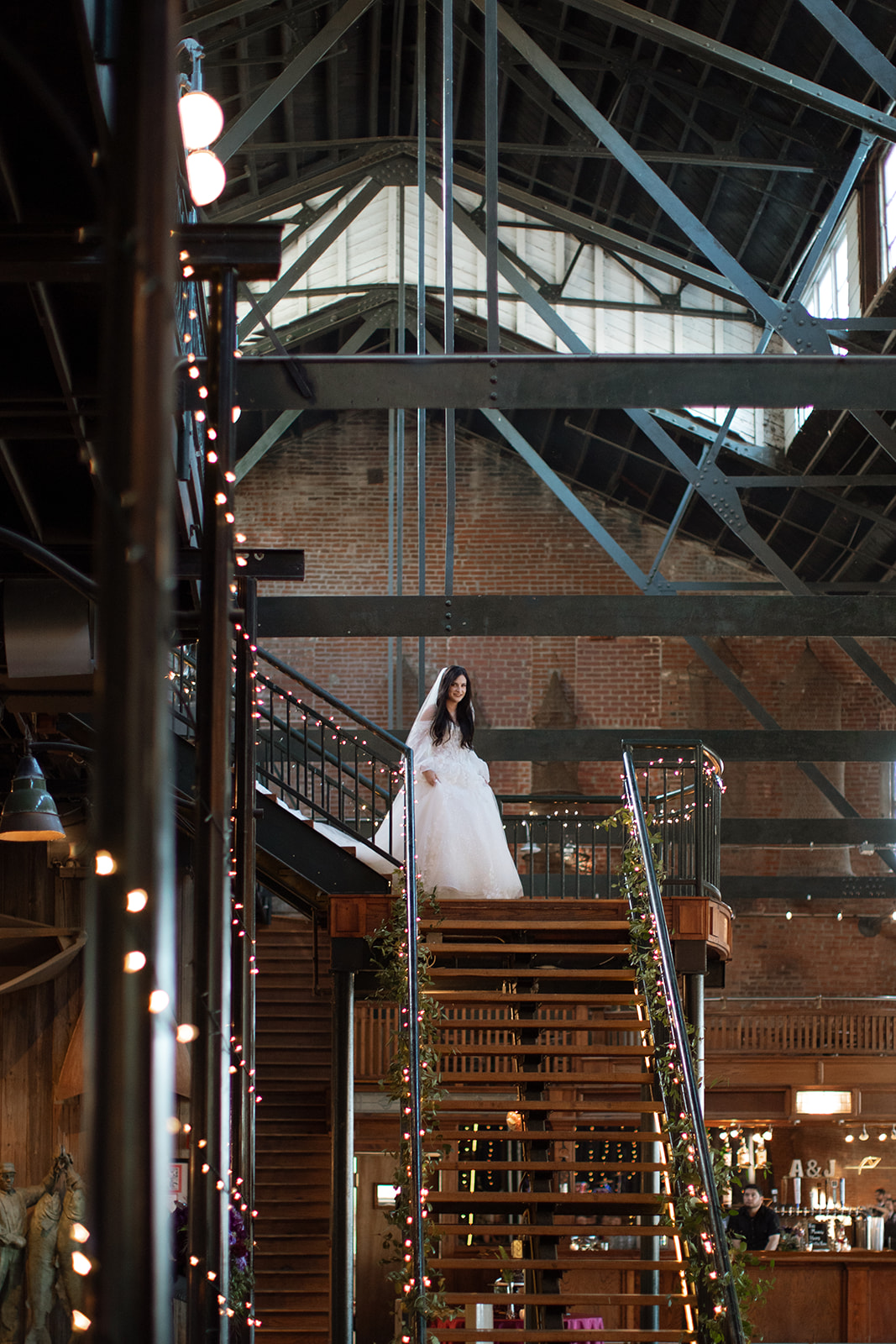 A bride walks down the grand staircase at Lawrence Wedding venue, Abe and Jakes Landing