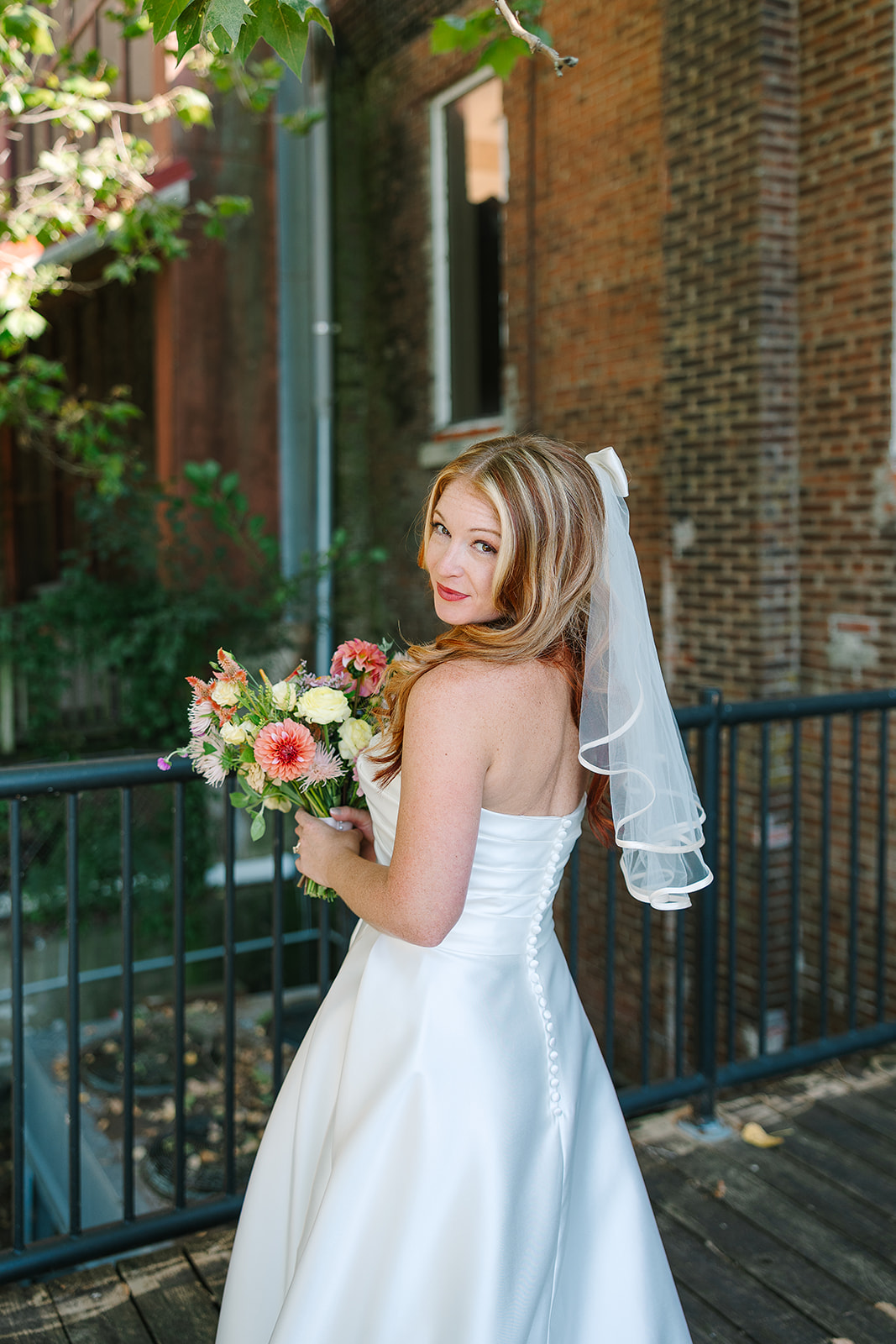 Bride smiles her shoulder at the camera