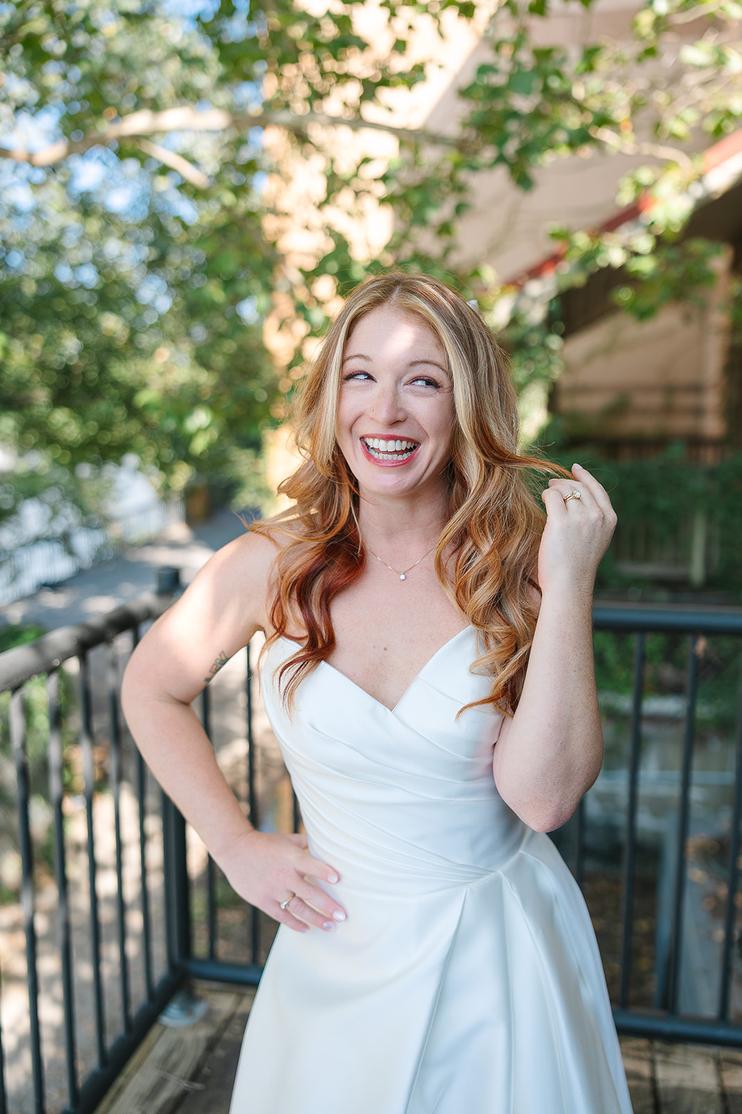 Bride smiles at the camera and plays with her hair