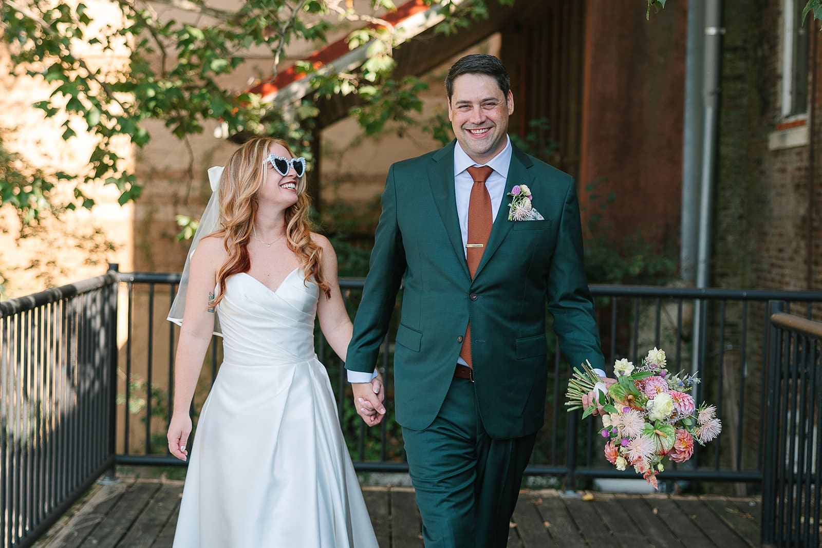 bride and groom walk hand in hand.