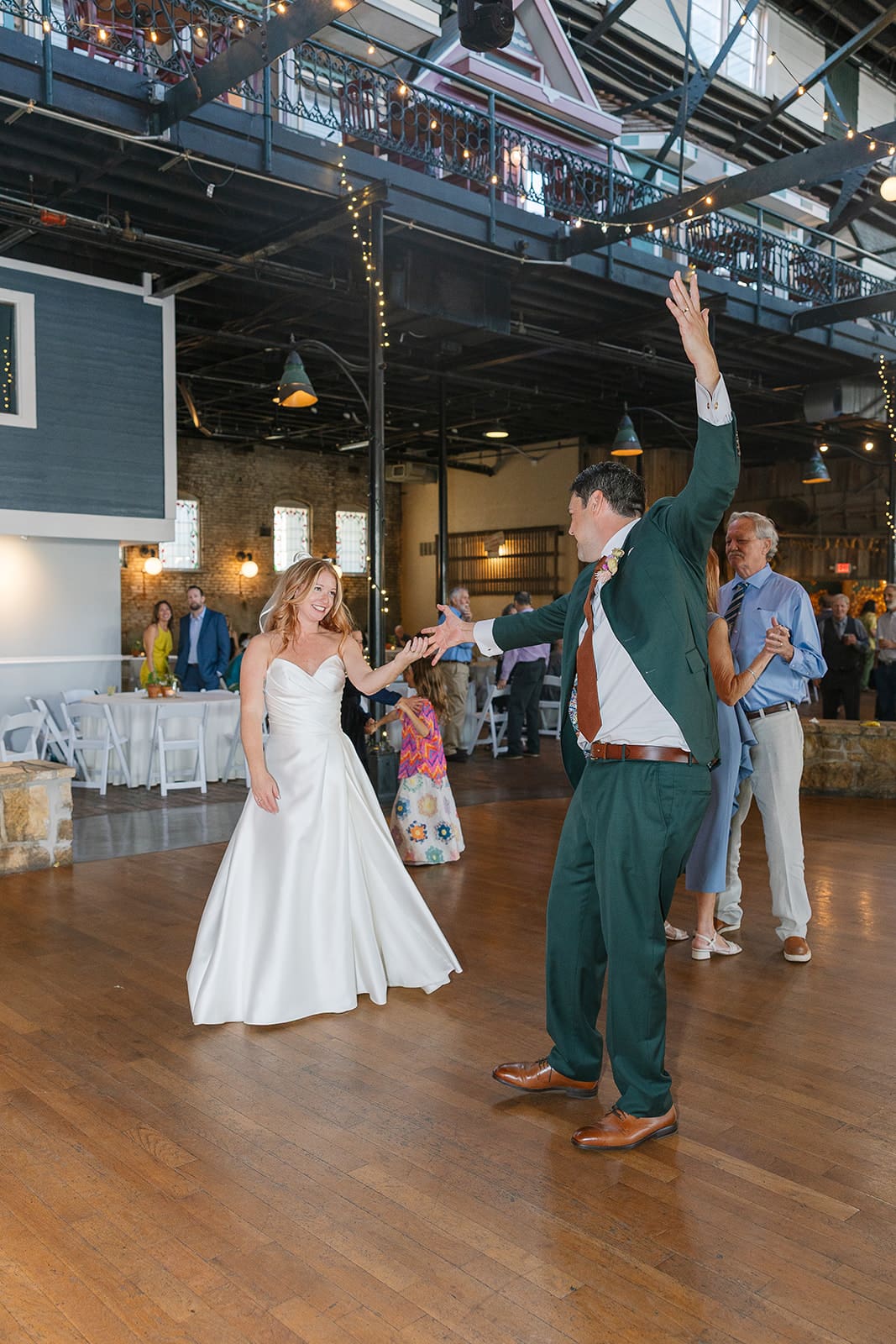 bride and groom dance while smiling